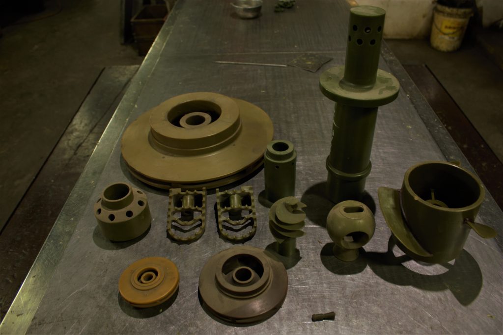 Assorted cast parts on an inspection table
